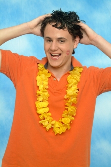 Photograph of a guy with a lei and a kiss on his cheek